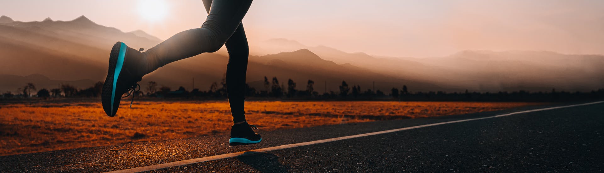 Un coureur de fond court devant des montagnes