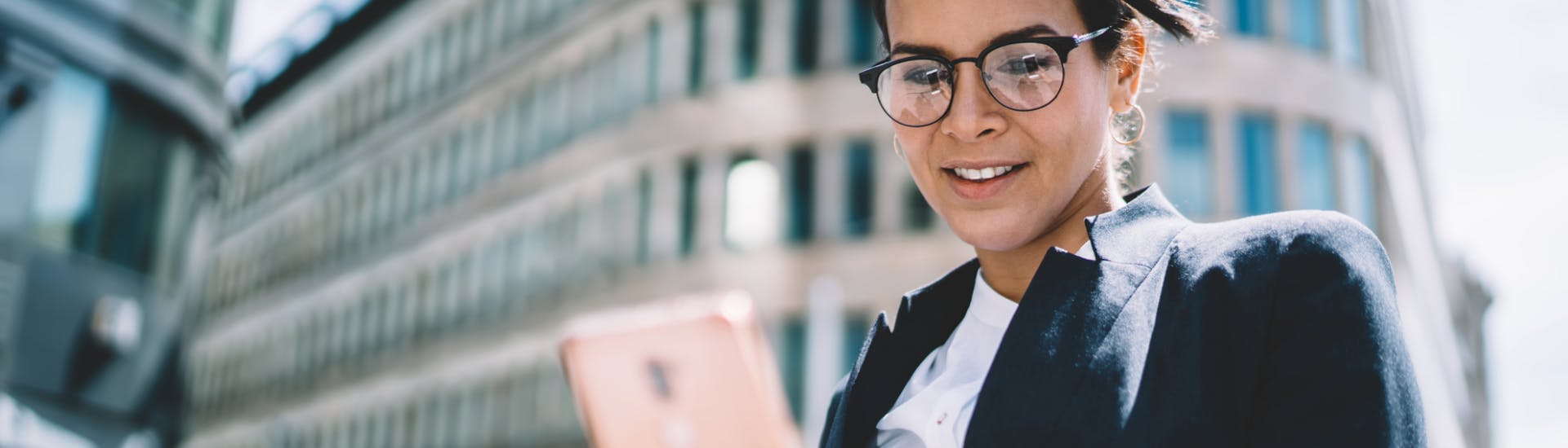 Une femme utilise l'application Visio Constat sur son smartphone pour contacter un huissier de justice.